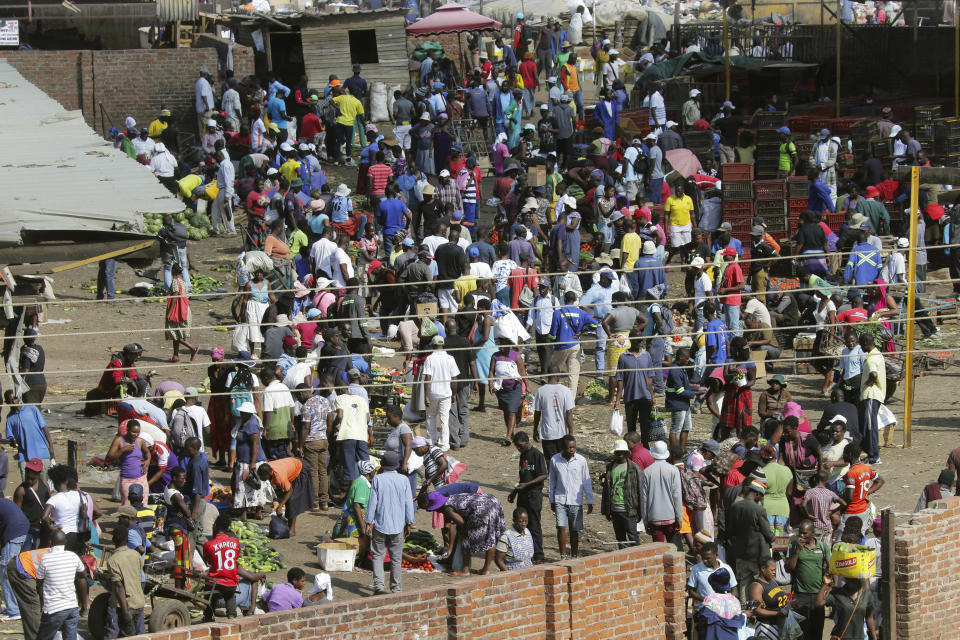 Hundreds of people buy goods at a fruit and vegetable market, despite a lockdown in an effort to curb the spread of the coronavirus, in Harare, Zimbabwe, Tuesday April 7, 2020. (AP Photo/Tsvangirayi Mukwazhi)