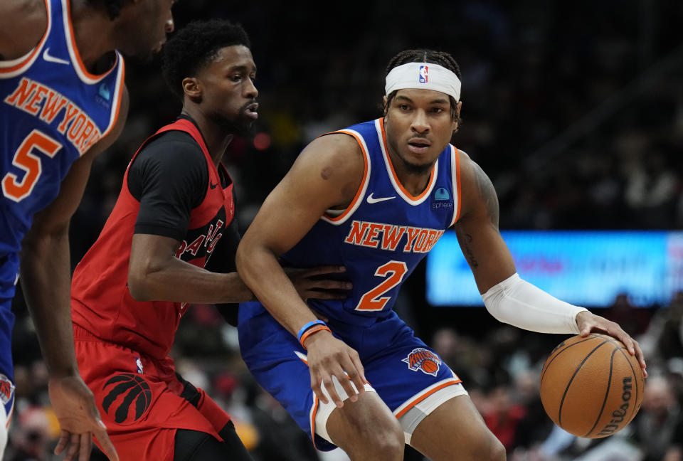New York Knicks guard Miles McBride (2) protects the ball from Toronto Raptors guard Kobi Simmons during the second half of an NBA basketball game Wednesday, March 27, 2024, in Toronto. (Frank Gunn/The Canadian Press via AP)