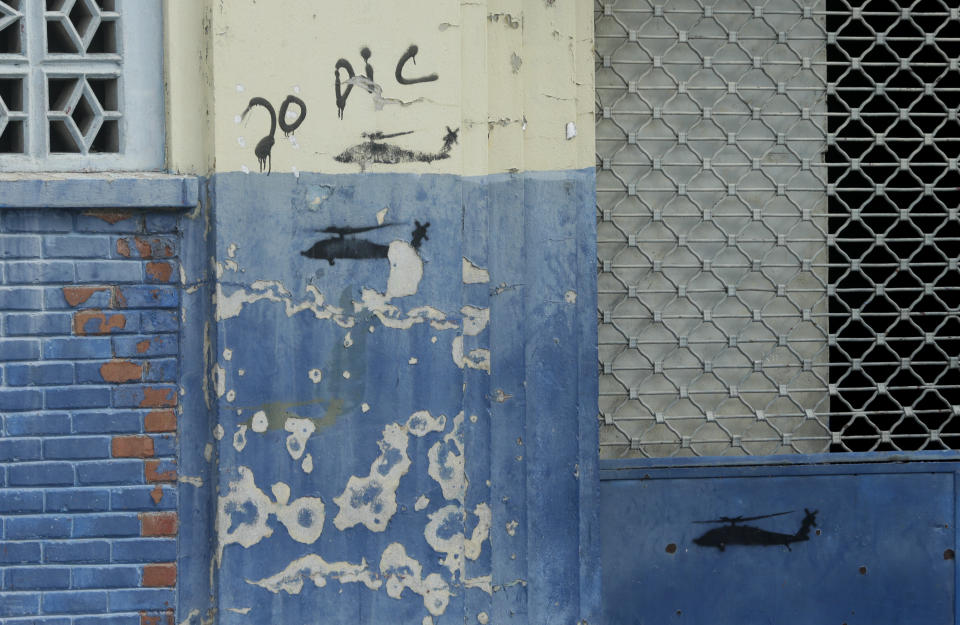 In this Dec. 4, 2019 photo, graffiti of the date Dec. 20 and depictions of helicopters, alluding to the 1989 U.S. invasion, covers a wall in the El Chorrillo neighborhood which bombed during the invasion in Panama City. Many of the Panamanian dead were buried in common graves, and at the request of relatives, exhumations led to the identification of many of the bodies. (AP Photo/Arnulfo Franco)