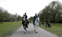 Mounted police ride along the Long Walk as they patrol round Window castle in Windsor, England, Friday, April 16, 2021. Prince Philip husband of Britain's Queen Elizabeth II died April 9, aged 99, his funeral will take place Saturday at Windsor Castle in St George's Chapel. (AP Photo/Alastair Grant)