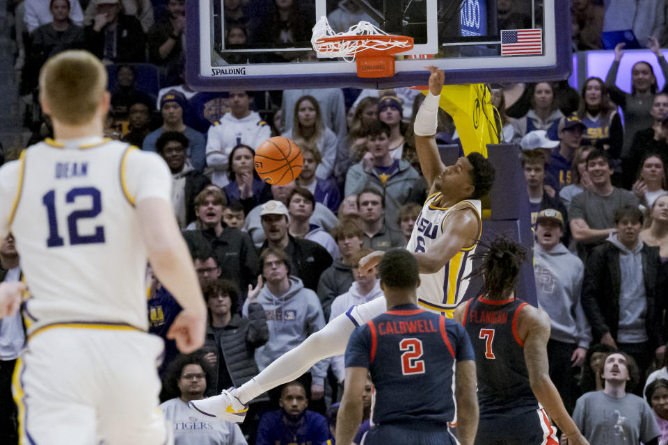 LSU guard Jordan Wright (6) dunks next to Mississippi guard TJ Caldwell (2) and guard Allen Flanigan (7) during the first half of an NCAA college basketball game in Baton Rouge, La., Wednesday, Jan. 17, 2024. (AP Photo/Matthew Hinton)