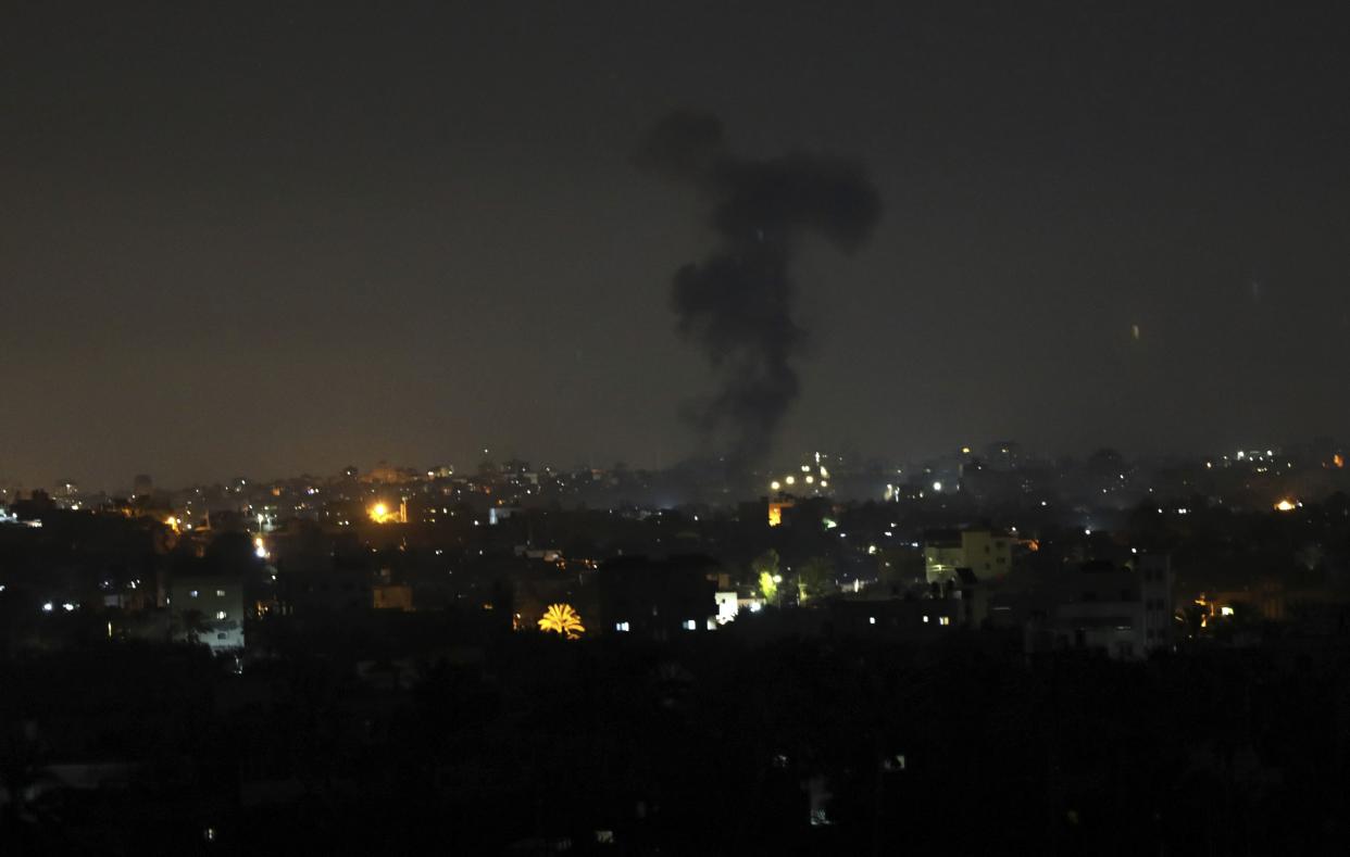 Explosions light-up the night sky above buildings in Gaza City as Israeli forces shell the Palestinian enclave, early on June 16, 2021.