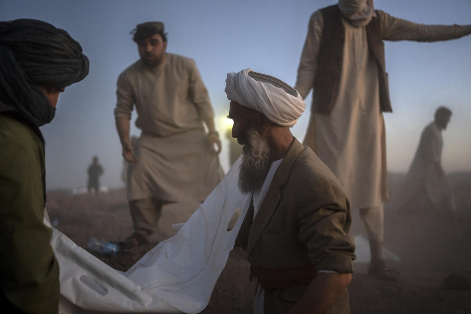 Afghans bury hundreds of people killed in an earthquake at a burial site, outside a village in Zenda Jan district in Herat province, western of Afghanistan, Monday, Oct. 9, 2023. Saturday's deadly earthquake killed and injured thousands when it leveled an untold number of homes in Herat province. (AP Photo/Ebrahim Noroozi)