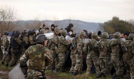 Migrants comfront Macedonian police officers after trying to cross the border from Greece into Macedonia, near Gevgelija, Macedonia, November 26, 2015. REUTERS/Stoyan Nenov