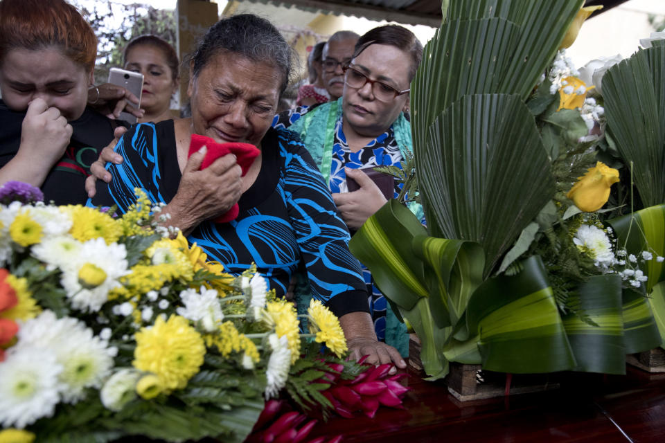 In this Oct. 31, 2018 photo, Haydee Posadas cries during the burial service for her son Wilmer Gerardo Nunez, at a cemetery in San Pedro Sula, Honduras. Two weeks after Nunez left Honduras for the U.S, when Posadas turned on the television news, fear suddenly gripped her. Authorities had found 72 corpses of migrants on a ranch in San Fernando, across the border from Texas. (AP Photo/Moises Castillo)