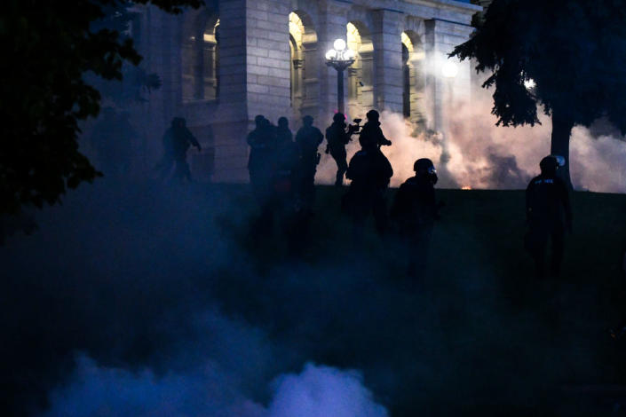 Police officers shoot tear gas as they disperse a crowd during a protest Friday. (Photo by Michael Ciaglo/Getty Images)