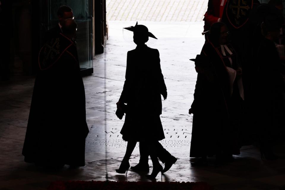 Kate Middleton and her children walk through Westminster Abbey in silhouette.
