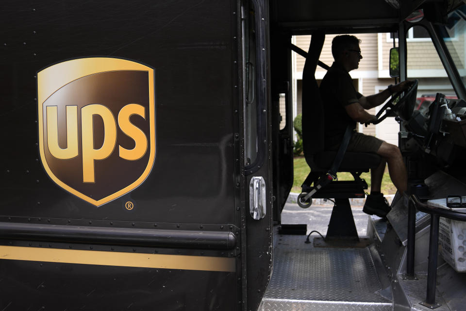 FILE - United Parcel Service driver Hudson de Almeida steers through a neighborhood while delivering packages, Friday, June 30, 2023, in Haverhill, Mass. UPS has reached a contract agreement with its 340,000-person strong union Tuesday, July 25, averting a strike that had the potential to disrupt logistics nationwide for businesses and households alike. (AP Photo/Charles Krupa, File)