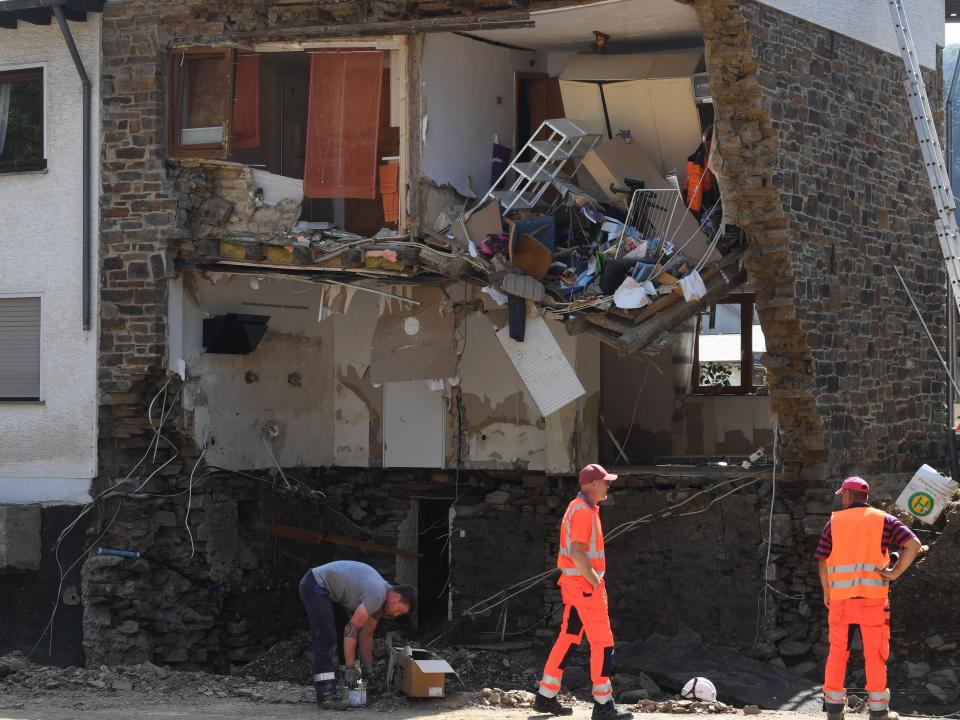 Emergency crews stand outside a severely damaged building after floods hit parts of Germany.