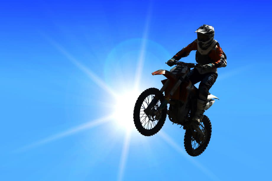 motorcycle jumping from a high rock