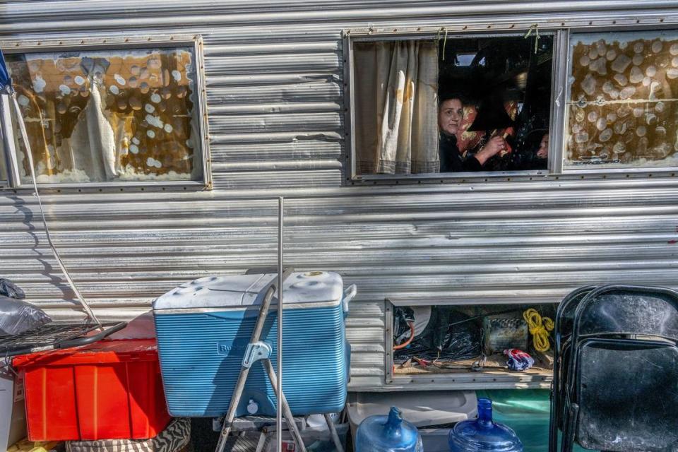 Tracy Ruberto, 50, who lives in an RV with her husband Anthony Roberto, 49, peers outside an open window in North Highlands in November. The homeless couple, who have two dogs, said they are tired of having no place to park their RV but worry that the proposed “Safe Stay” parking lot wouldn’t allow their run-down RV.