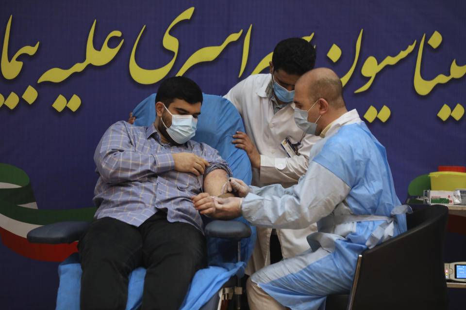 Parsa Namaki son of Health Minister Saeed Namaki receives a Russian Sputnik V coronavirus vaccine in a staged event at Imam Khomeini Hospital in Tehran, Iran, Tuesday, Feb. 9, 2021. Iran on Tuesday launched a coronavirus inoculation campaign among healthcare professionals with recently delivered Russian Sputnik V vaccines as the country struggles to stem the worst outbreak of the pandemic in the Middle East with its death toll nearing 59,000. (AP Photo/Vahid Salemi)