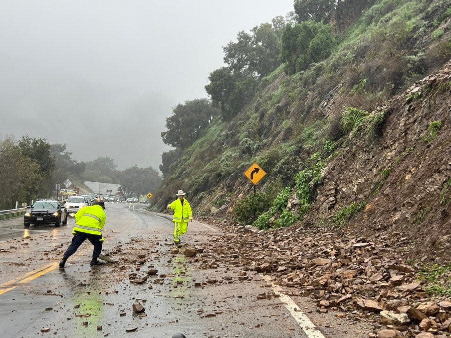 Crews clean up rocks and mud that spilled onto Highway 33 near Creek Road Tuesday afternoon.