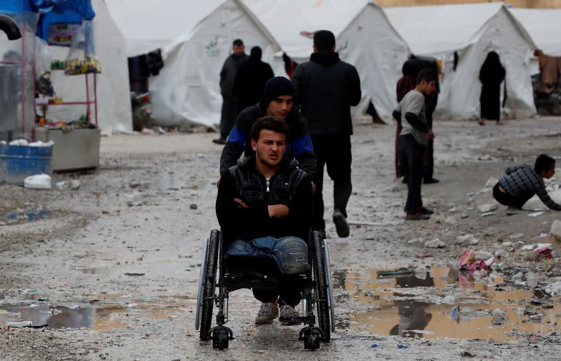 Internally displaced Syrian is pushed in a wheelchair along the tents in an IDP camp located in Idlib