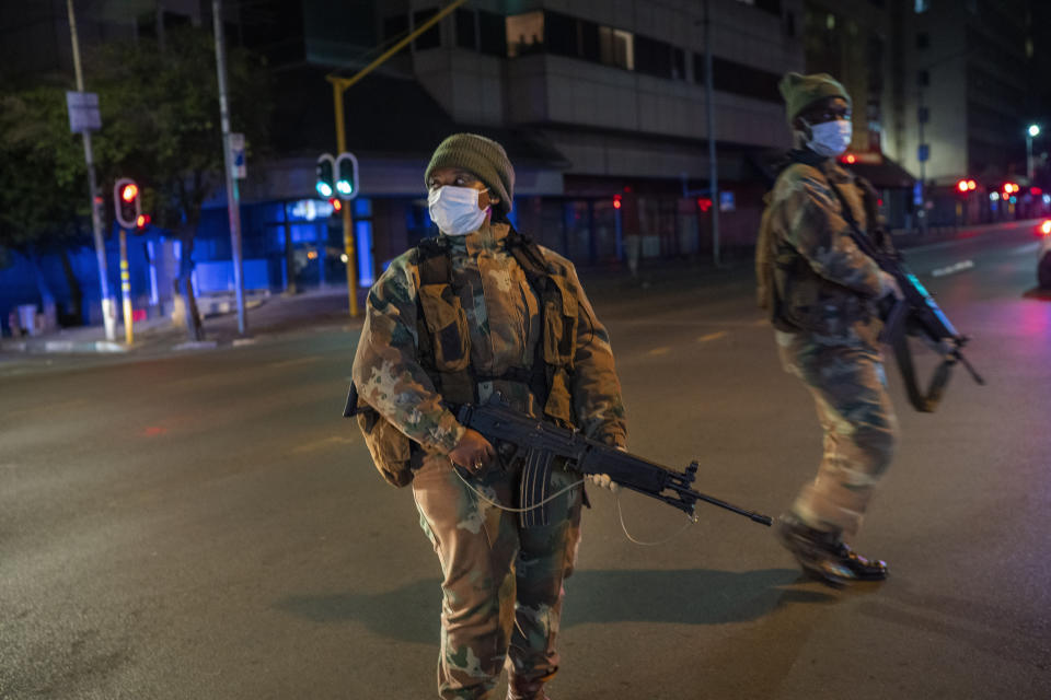 South African Defense Forces patrol downtown Johannesburg, South Africa, Friday, March 27, 2020. Police and army started patrolling moments after South Africa went into a nationwide lockdown for 21 days in an effort to mitigate the spread to the coronavirus. The new coronavirus causes mild or moderate symptoms for most people, but for some, especially older adults and people with existing health problems, it can cause more severe illness or death.(AP Photo/Jerome Delay)