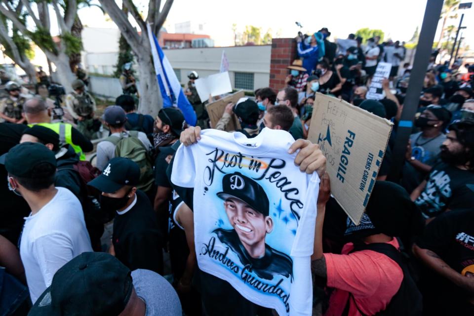 A demonstrator holds a T-shirt with Andres Guardado on it at a rally