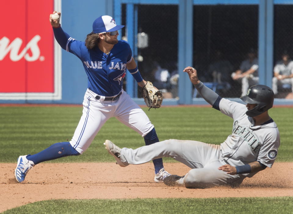 Seattle Mariners' Tim Lopes is out on the force out at second base as Toronto Blue Jays Bo Bichette turns the double play in the ninth inning of their baseball game in Toronto Sunday Aug. 18, 2019. (Fred Thornhill/The Canadian Press via AP)