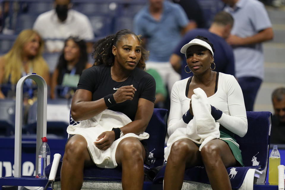 Serena Williams (izquierda) y Venus Williams sentadas durante su partido de dobles contra Lucie Hradecká y Linda Nosková en el US Open, el jueves 1 de setptiembre de 2022, en Nueva York. (AP Foto/Charles Krupa)