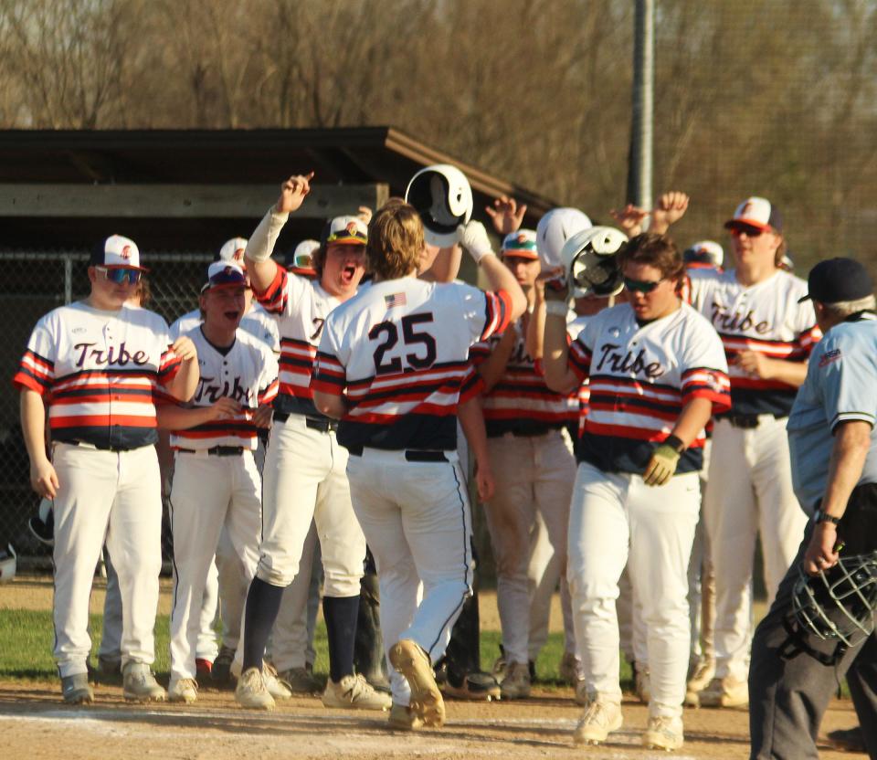 Zechariah Landstrom receives congratulations from his Pontiac teammates as he crosses home plate after belting a two-run homer Tuesday. Landstrom drove in three runs and got the win on the hill as the Indians defeated Peoria Christian 15-3 at The Ballpark at Williamson Field.
