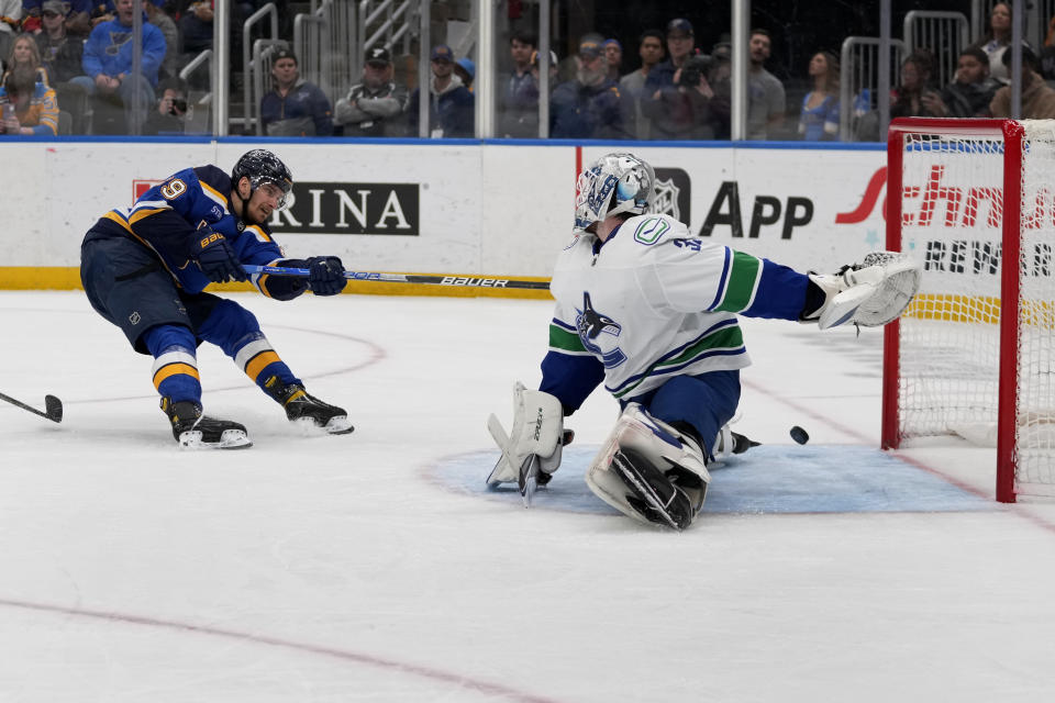 St. Louis Blues' Pavel Buchnevich, left, scores past Vancouver Canucks goaltender Thatcher Demko during the second period of an NHL hockey game Tuesday, March 28, 2023, in St. Louis. (AP Photo/Jeff Roberson)