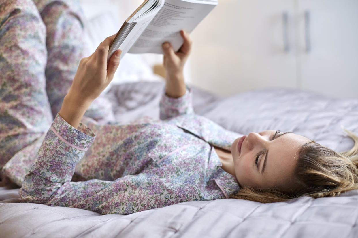 Woman in pyjamas reading a book