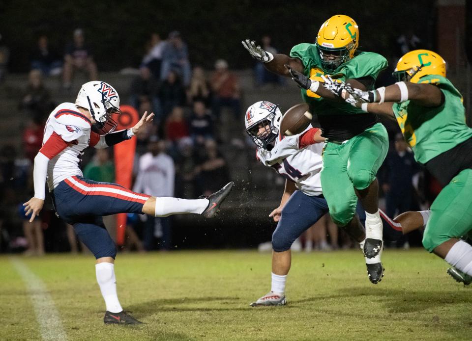 Timothy Gulley (66) blocks the punt by Chase Linville (21) which is recovered by teammate Desjon Robertson (55) during the Wakulla vs Catholic football game at Pensacola Catholic High School in Pensacola on Friday, Nov. 11, 2022.