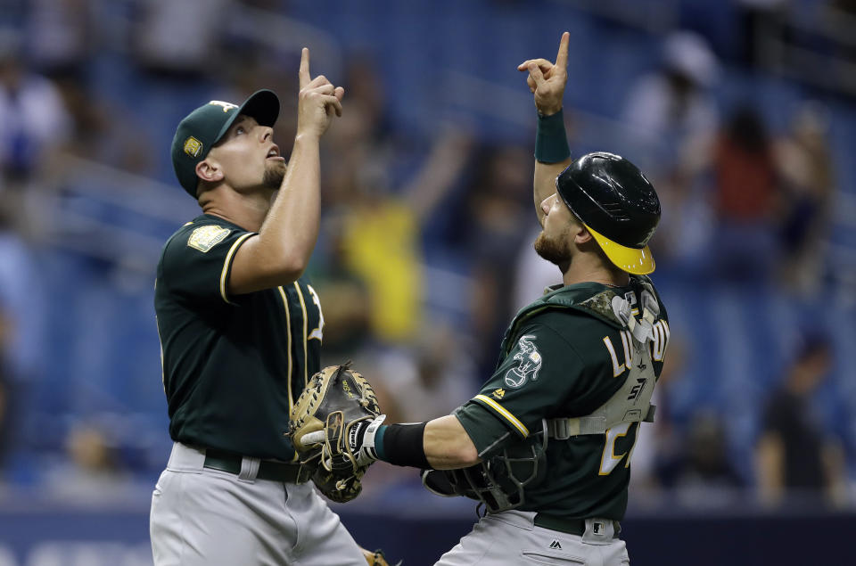Oakland Athletics pitcher Blake Treinen, left, celebrates with catcher Jonathan Lucroy after defeating the Tampa Bay Rays 2-1 during a baseball game Friday, Sept. 14, 2018, in St. Petersburg, Fla. (AP Photo/Chris O'Meara)