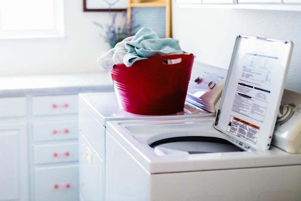 Laundry room with top-loading washing machine open