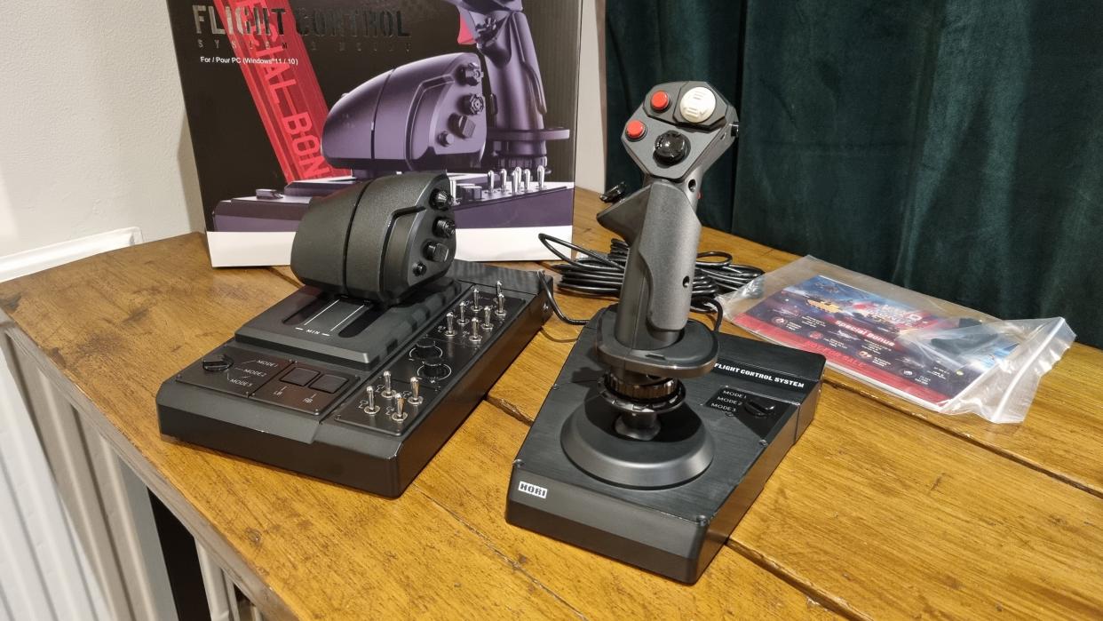  The Hori HOTAS Flightstick and throttle control, displayed in front of the box on a desk. 