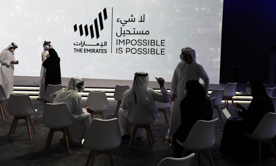 Emiratis talk before an event announcing new economic programs in the United Arab Emirates in Dubai, United Arab Emirates, Sunday, Sept. 5, 2021. The United Arab Emirates announced Sunday a major plan to stimulate its economy and liberalize stringent residency laws for expatriates, as the country seeks to overhaul its finances and attract foreign residents and capital. (AP Photo/Jon Gambrell)