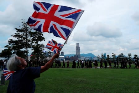 A protester waves the Union Jack as legal professionals stage a silent protest to demand authorities scrap a proposed extradition bill, in Hong Kong
