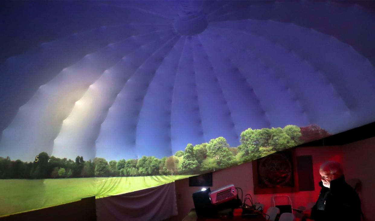 Battle Point Astronomical Association chief scientist Steve Ruhl is illuminated by the tablet in his hands as he starts up the new projector in the John H. Rudolph Planetarium in Bainbridge Island's Battle Point Park on Thursday, Feb. 16, 2023.