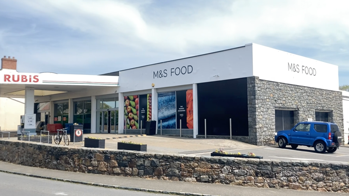 Marks and Spencer foot in St Martins. A gre, square building with a small petrol station attached.