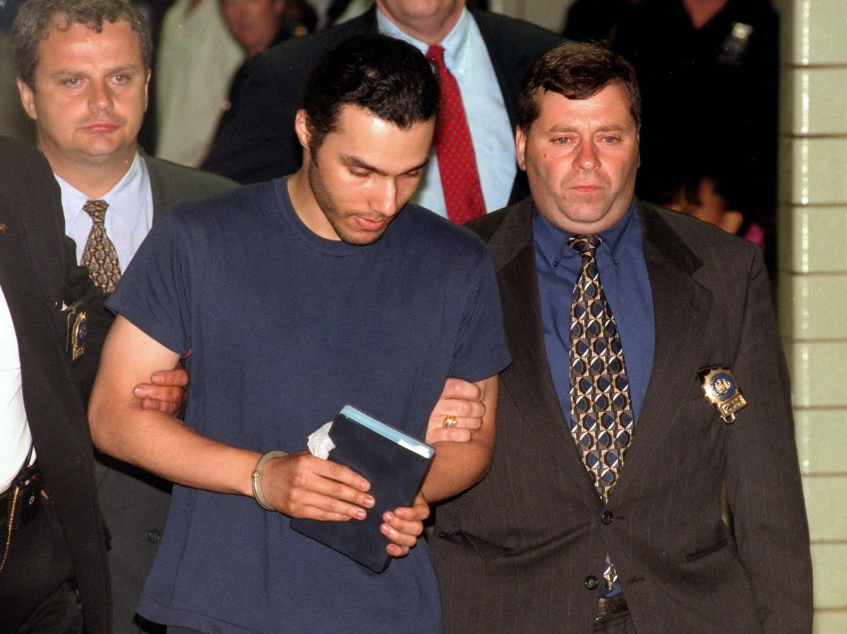 Heriberto Seda is led out of the NYPD’s 75th precinct stationhouse following his arrest in 1994  (NY Daily News via Getty)