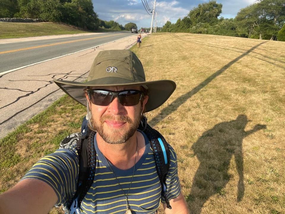 Jonathon Stalls takes a selfie while walking with friend Nicole Huguenin along Boston Neck Road approaching Narragansett Town Beach. This moment marked the last of their 18 miles traveling together from East Greenwich.