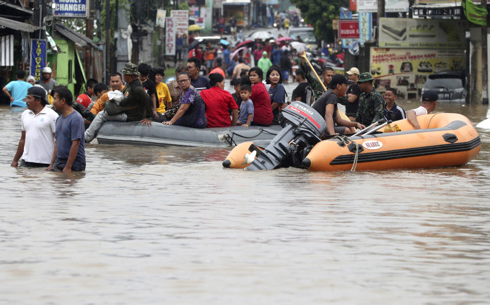 Indonesia rescue team evacuate residents from their flooded house at Jatibening out skirt of Jakarta, Indonesia, Wednesday, Jan. 1, 2020. Severe flooding hit Indonesia's capital just after residents celebrating New Year's Eve, forcing a closure of an airport and thousands of inhabitants to flee their flooded homes.(AP Photo/Achmad Ibrahim)