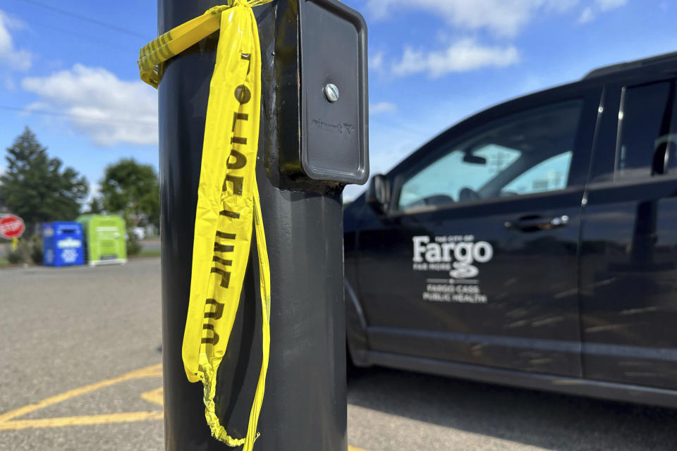 Police crime tape remained Saturday, July 15, 2023, in Fargo, N.D., near the intersection where one police officer was fatally shot and two others were critically wounded on Friday, July 14. Authorities have said the suspect was also killed in the shooting, and a civilian was injured. (AP Photo/Jack Dura).