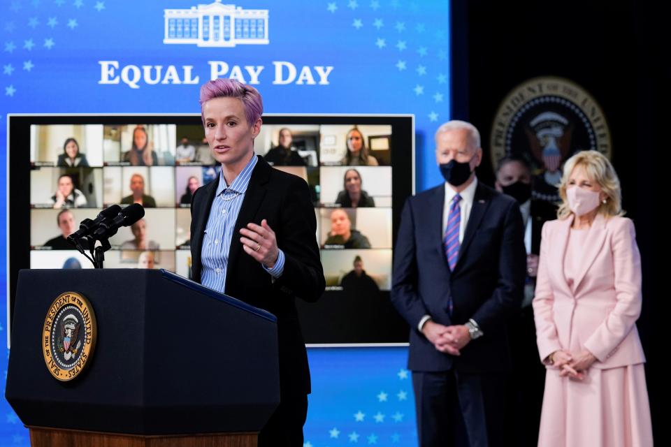 United States Soccer Women's National Team member Megan Rapinoe speaks as President Joe Biden and first lady Jill Biden look on during an event to mark Equal Pay Day in the South Court Auditorium in the Eisenhower Executive Office Building on the White House Campus Wednesday, March 24, 2021, in Washington.