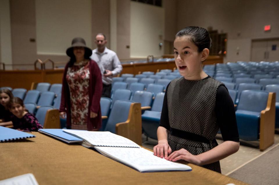 <span class="caption">Batya Sperling Milner, who is blind, recites her Torah portion during rehearsal for her bat mitzvah ceremony at Ohev Shalom, an Orthodox synagogue in Washington, D.C. A computer programmer added the Torah chant code to the braille Torah so she could learn to recite.</span> <span class="attribution"><a class="link " href="https://www.gettyimages.com/detail/news-photo/batya-sperling-milner-who-is-blind-recites-her-torah-news-photo/1083021590?adppopup=true" rel="nofollow noopener" target="_blank" data-ylk="slk:Evelyn Hockstein/For The Washington Post via Getty Images;elm:context_link;itc:0;sec:content-canvas">Evelyn Hockstein/For The Washington Post via Getty Images</a></span>
