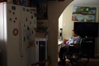 Francisca Perez, 84, sits by the dining table on a wheelchair in her house in Chicago's Little Village neighborhood, Wednesday, June 30, 2021. She suffers from a heart condition, rheumatoid arthritis and depression, among other ailments. Her daughter, Eugenia Rodriguez, hasn't been eligible for insurance coverage after overstaying a visitor visa from Mexico. She used to wake up every two or three hours at night to check on her mother. Since getting health insurance through the Illinois program, her mother has all the medications she needs. (AP Photo/Shafkat Anowar)