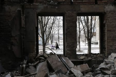 People are seen through the windows of a building damaged by fighting in the city of Debaltseve, February 20, 2015. REUTERS/Baz Ratner