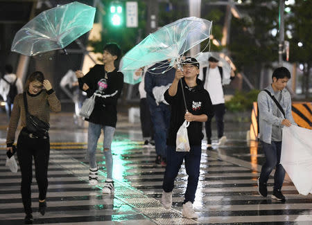 Passersby using umbrellas struggle against strong wind and rain caused by Typhoon Trami in Nagoya, central Japan, in this photo taken by Kyodo September 30, 2018. Mandatory credit Kyodo/via REUTERS