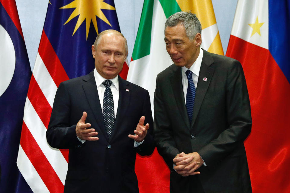 Russian President Vladimir Putin speaks with Singapore's Prime Minister Lee Hsien Loong during a group photo at the ASEAN-Russia Summit in Singapore, November 14, 2018. REUTERS/Edgar Su