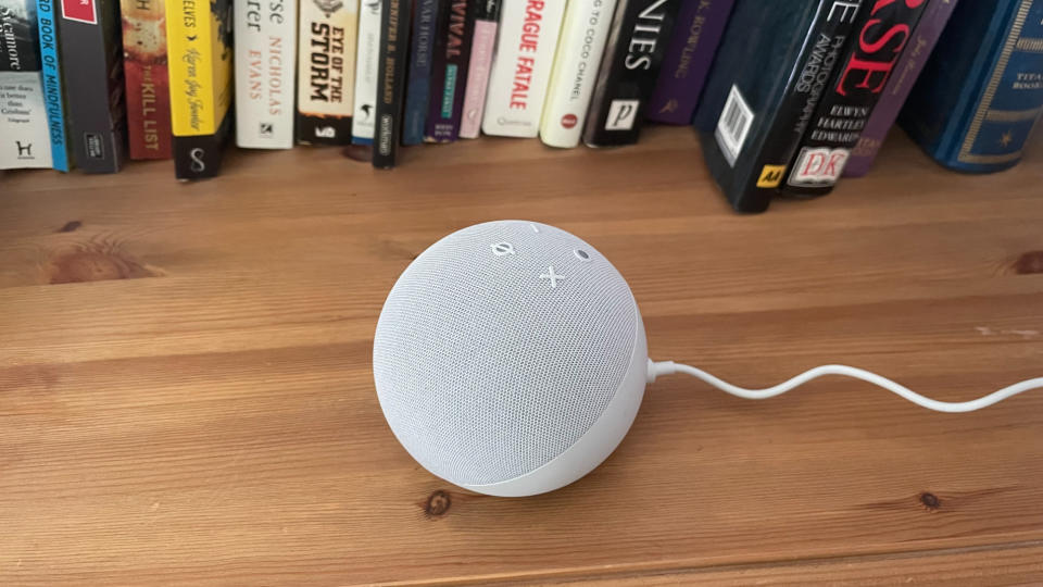 Echo Dot 5th gen on a bookshelf in front of books