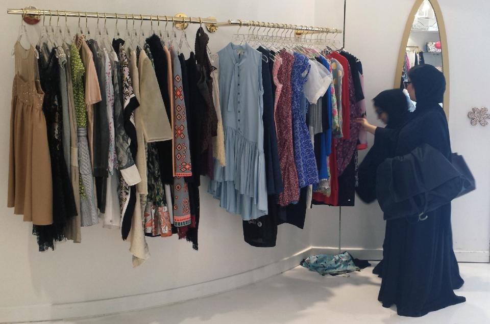 In this Jan. 30, 2014 photo, two Emirati women look at designer clothes at Sauce boutique in Dubai, United Arab Emirates. Dubai and luxury are nearly synonymous. The city is home to the world’s tallest tower, massive manmade islands in the shape of palm trees and a fleet of police cars that include a Ferrari, Lamborghini and a $2.5 million Bugatti Veyron. To boost its glamour factor and economy, the city has its eyes set on the multi-billion dollar a year global fashion industry, which is currently dominated by the U.S., Europe and Japan. (AP Photo/Aya Batrawy)