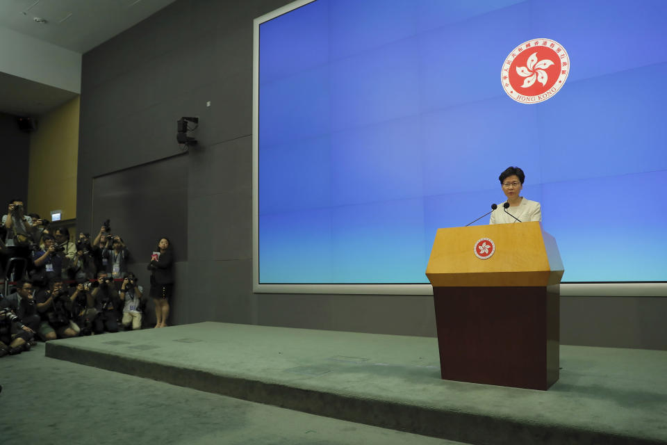 Photographers aim at Hong Kong Chief Executive Carrie Lam speak on stage during a press conference at the Legislative Council in Hong Kong, Tuesday, June 18, 2019. Lam apologized Tuesday for an unpopular extradition bill that drew massive protests and indicated that it will not be revived during the current legislative session. (AP Photo/Kin Cheung)