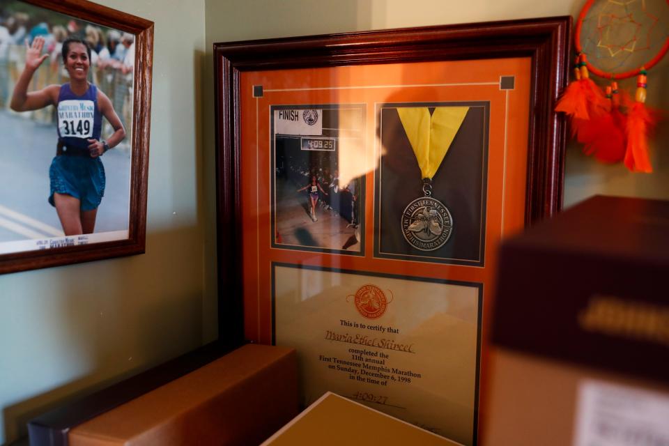 Maria Shircel keeps a framed medal and certificate from the first marathon she ran at Maria Shircel Realty in Clarksville, Tenn., on Wednesday, Jan. 12, 2022. 