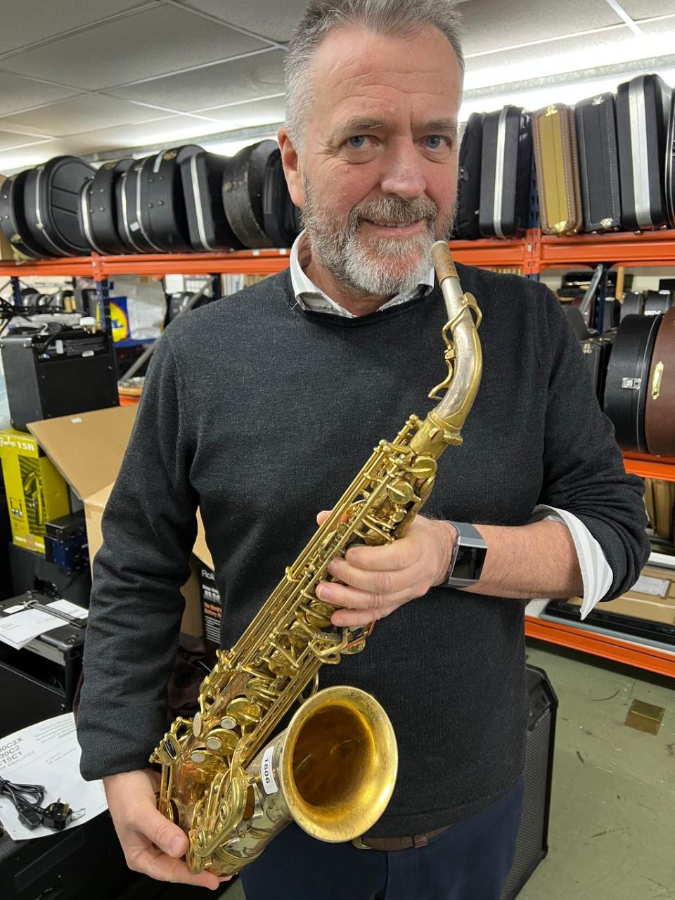 Auctioneer Jamie South with a saxophone belonging to Peter King (Gardiner Houlgate/PA)