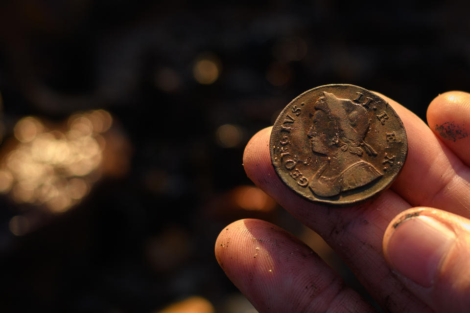LONDON, ENGLAND - OCTOBER 20: Mudlark Jason Sandy holds out a coin dated 1737, from the reign of Britain's King George II, after discovering it during a search of the shoreline of the River Thames for historical items on October 20, 2018 in London, England. Moving to London eleven years ago, US-born Jason Sandy fell in love with the history that was available to explore on his doorstep and now has over 35,000 followers on his instagram feed 