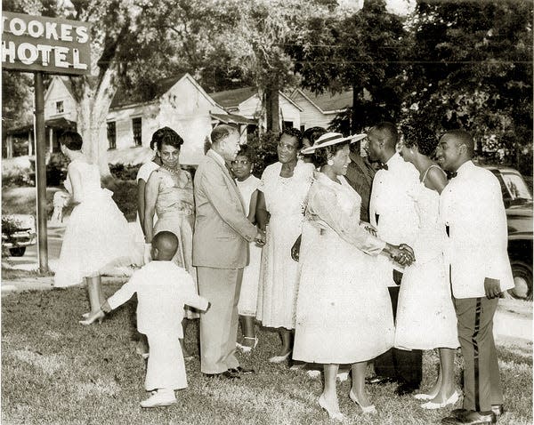 Dorothy Nash Tookes greeting guests in front of her hotel after her son's wedding (1958).